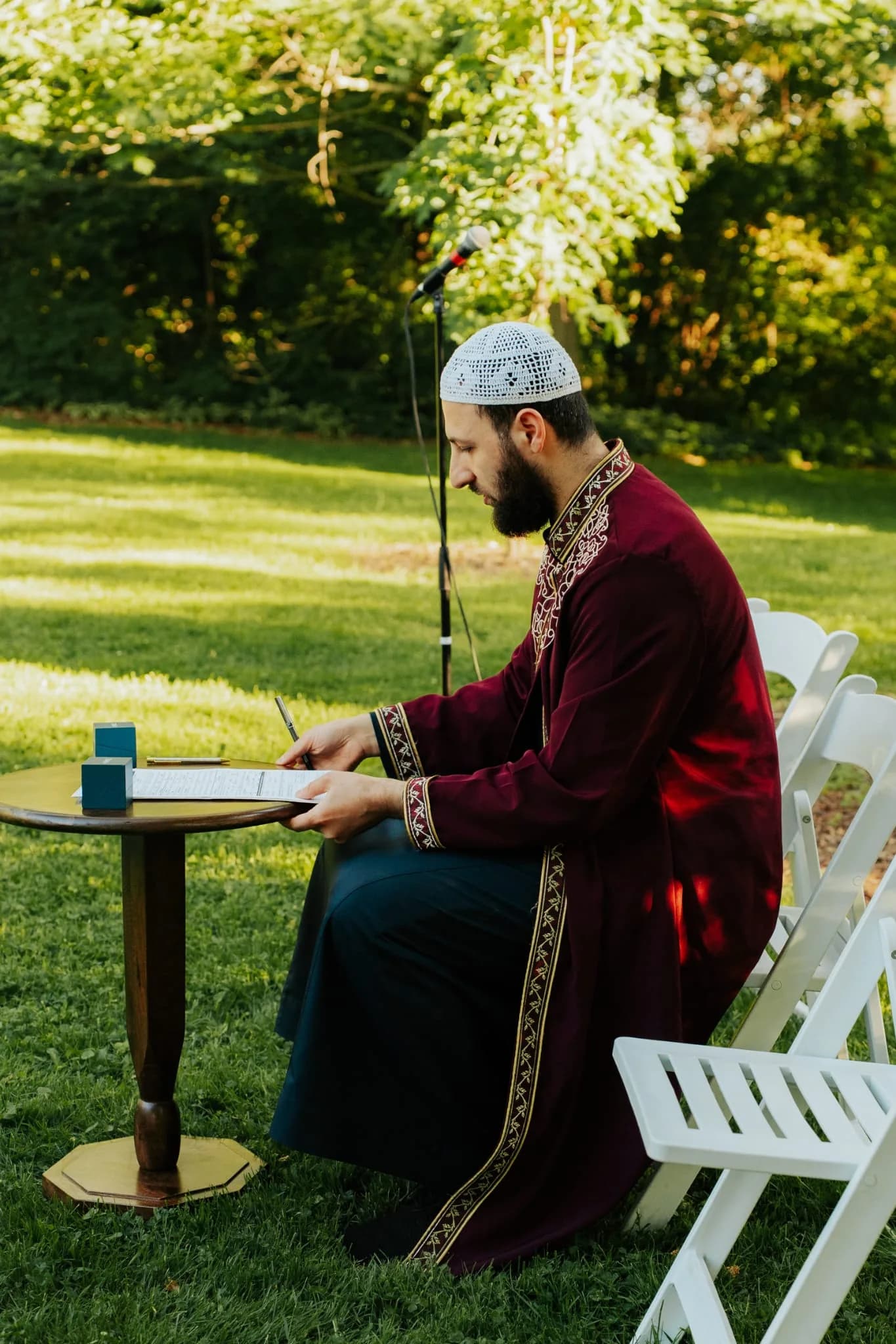 Imam Zaniar Ahmad preparing ceremony documents outdoors